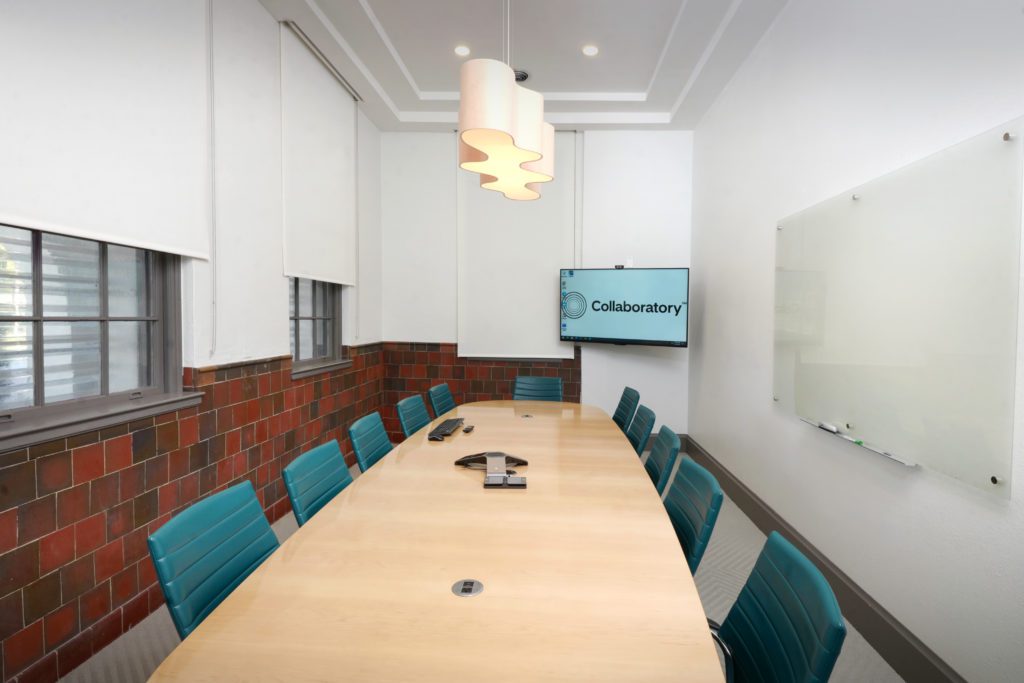 A conference room with a large table and chairs.