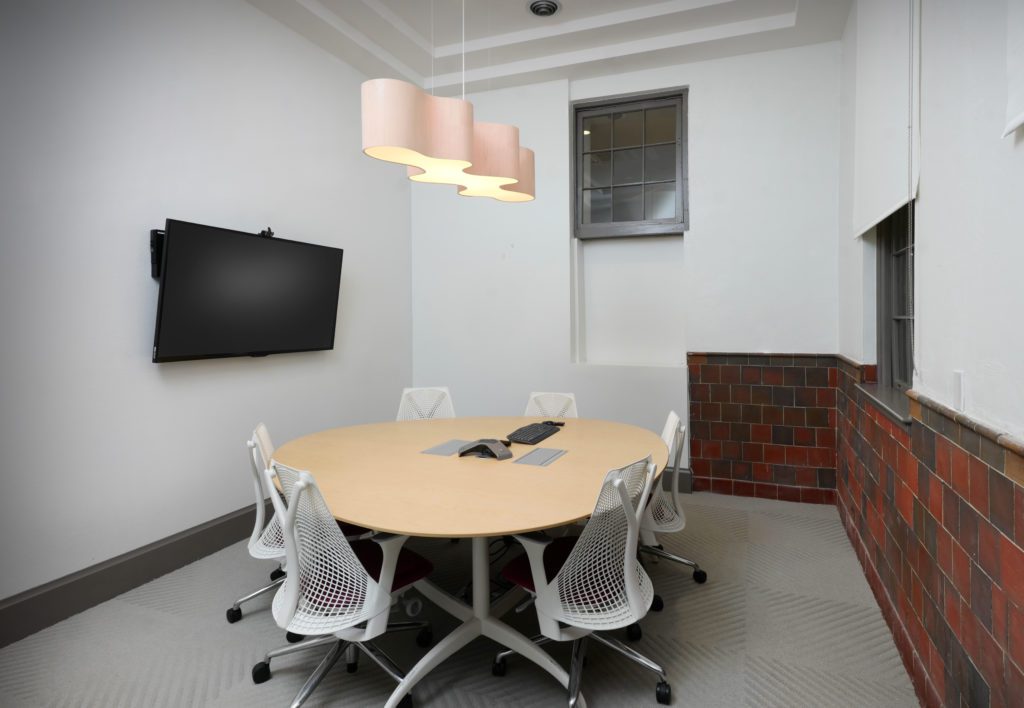 A conference room with a round table and chairs.