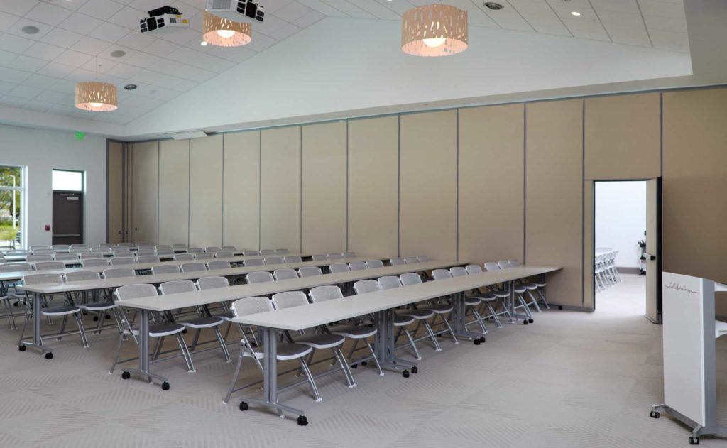 A conference room with white tables and chairs.