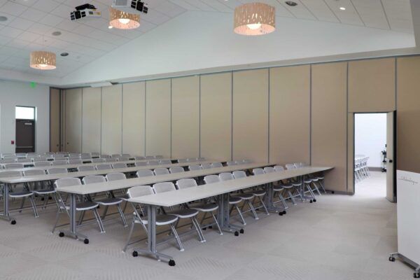 A conference room with white tables and chairs.