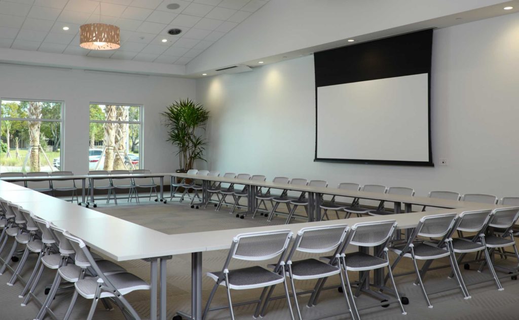 A conference room with chairs and a projection screen.