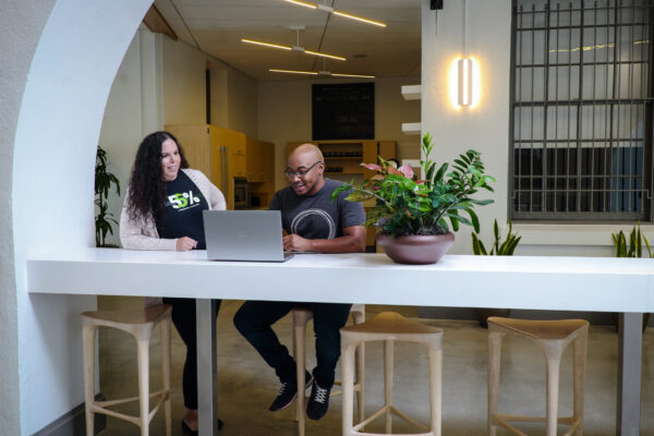 Two people sitting at a desk in an office.