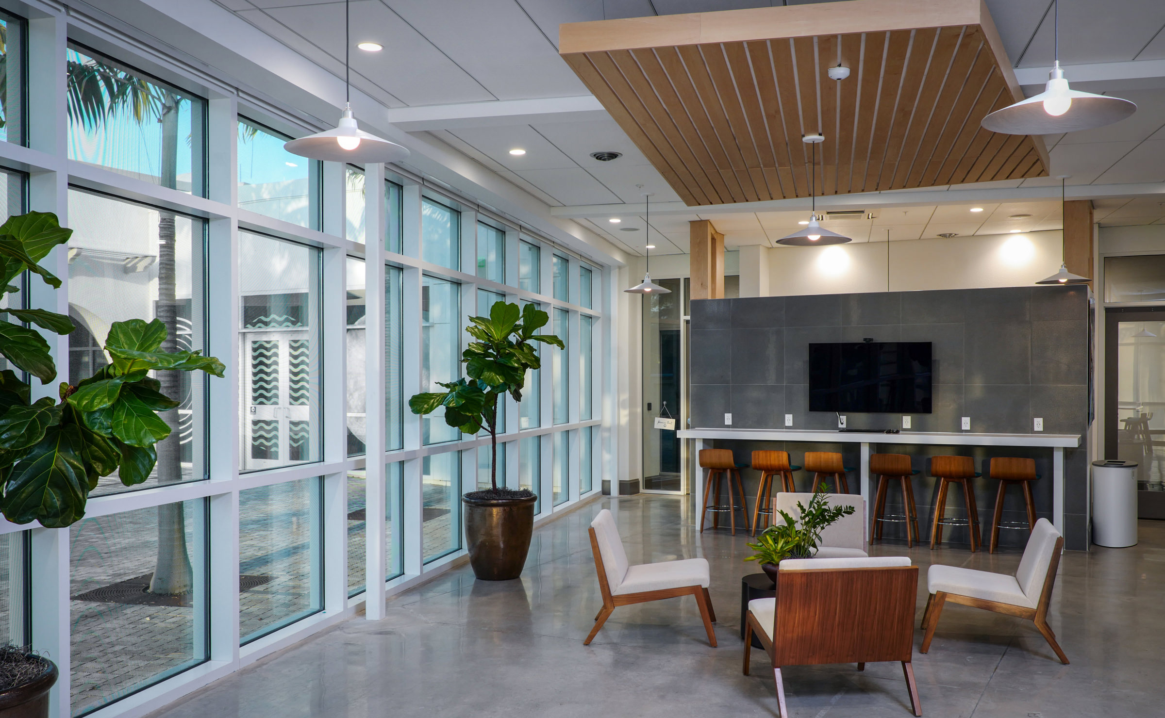 A modern lobby with large windows and a tv.
